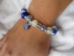 Bracelet élastiqué de perles de verre artisanal et de perles ethniques en métal argenté, breloques de cuivre émaillé pailleté, bleu et blanc