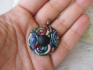 Pendentif bouton rond en pâte polymère avec motif de spirales multicolores sur fond noir et cabochon rond noir mat