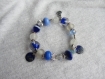 Bracelet élastiqué de perles de verre artisanal et de perles ethniques en métal argenté, breloques de cuivre émaillé pailleté, bleu et blanc