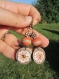 Boucles d'oreilles pendantes, breloque sequin disque de cuivre avec fleur émaillée, perle de verre filé, blanc et orange, fleur en métal