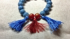 Bracelet perles irisées bleus et rougesavec pompons