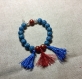 Bracelet perles irisées bleus et rougesavec pompons