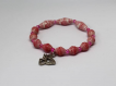 Bracelet fantaisie élastique en perles de papier rose foncé et breloque papillon