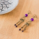 Boucles d'oreilles en métal brun, avec petite oiseau. couleur violet avec perles.