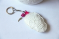 Porte-clé tête de mort blanche en simili cuir avec perle rose et breloque aile