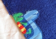 Bavoir enfant en éponge bleu roi avec des dinosaures