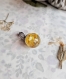 Collier boule sphère en résine avec incrustation de fleur jaune
