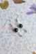 Boucles d'oreilles pendantes avec perles noires en verre, calottes tibétaines et charms argentés