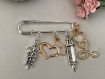 Broche épingle en métal doré et argenté thème infirmière, caducée, coiffe, seringue et stéthoscope