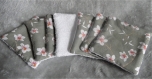 Lot de 7 lingettes démaquillante fait main tissu coton motif fleur d'amandier blanche sur fond vert et éponge bambou blanche.