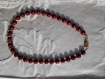Collier en perles de verre rouge laquées à motifs et perles gouttes de métal doré. 45 cm.