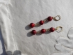 Boucles d'oreilles en perles de verre rouge laquées à petits motifs. 70 mm.
