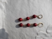 Boucles d'oreilles en perles de verre rouge laquées à petits motifs. 70 mm.