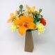 Composition florale en papier des fleurs oranges et jaunes dans un vase en carton - le bouquet contient: cosmos, oeillets, lis et soucis