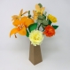 Composition florale en papier des fleurs oranges et jaunes dans un vase en carton - le bouquet contient: cosmos, oeillets, lis et soucis