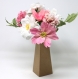 Composition florale de fleurs roses et blanches faites main en papier crépon dans un vase en carton