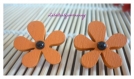 Boucles d'oreille fleur en bois orange et petit cabochon noir. 