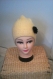 Bonnet jaune clair tricoté et décoré d'une marguerite crochetée noire 
