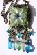 Collier sautoir en bronze avec perles de verre vertes bleues et transparentes ornées d'une fleur blanche
