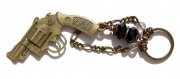 Porte-clefs avec perles de verre noires à facettes et agrémentées d'un révolver en bronze 