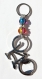 Porte-clés argenté avec un décapsuleur en vélo stylisé et deux perles de verre bicolores 