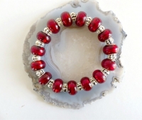Bracelet élastique perles de verre rouges et perles métal argenté.
