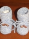 Chaussons bebe blanc et bleu agremente de boutons en forme de  moustache