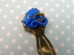 Marque-pages doré et poulpe bleu tenant sa clef en bronze en pâte polymère