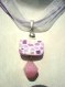 Pendentif constitué d'une perle rectangulaire en pâte fimo, à motif vitrail rose, violet et blanc avec une perle en verre rose suspendue.