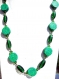 Collier constitué de perles rondes plates en pâte fimo, avec motif vert et petite touches bleues ciel.