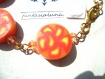 Bracelet taille m constitué de 5 perles rondes plates en pâte fimo, au motif fleur jaune, rouge et orange