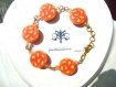 Bracelet taille m constitué de 5 perles rondes plates en pâte fimo, au motif fleur jaune, rouge et orange