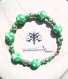 Bracelet taille s constitué de 6 perles rondes, en pâte fimo, au motif pois verts et blanc dégradés, entourées de calottes fleur argentées, de perles en verre vertes et de perles argentées.