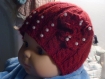 Bonnet bébé rouge garni de perles.