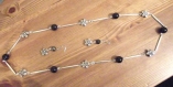 Collier de fleurs argentée et perles noires avec ses boucles d'oreille assorties