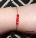 Bracelet chaîne dorée et perles à facettes rouges 