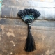 Broche textile, eventail noir et plumes de paon