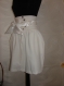 Ladies white skirt with set and non-standard fastening, lining and belt with satin ribbon