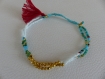 Bracelet d'amitié en perles bleues pompon rouge