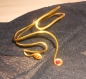 Joli bracelet d'avant-bras en fil alu doré lisse 4 mm avec strass rouge. 