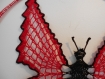 Papillon au crochet rouge borduré de noir dans arceau 