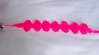Bracelet réalisé en macramé de couleur fushia 