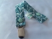 Baby box mini : attache-tétine et bavoir bandana aux motifs plume de paon dans les tons vert 