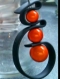 Boucles d'oreille pendantes pvc noir et perles magiques orange 