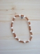Bracelet élastique en perles facettées couleur cuivre et os blanc 