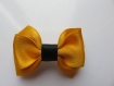 Barrette plastique 4 cm avec petit noeud papillon en tissu satin jaune d'or et noir 