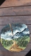 Sur une rondelle de bois peinture à main levée : paysage montagnard 