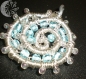 Pendentif spirale en wire et perles bleues.