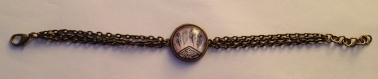 Bracelet en métal couleur bronze et son cabochon plumes 